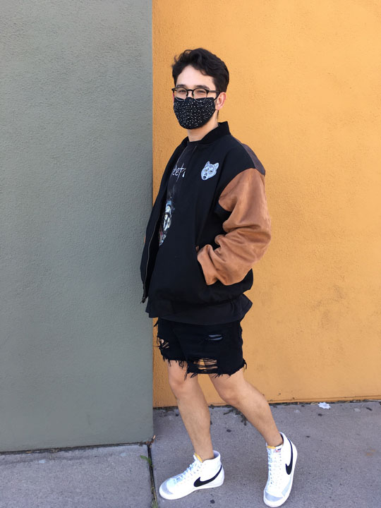 Buffalo Exchange employee wearing varsity jacket with brown leather sleeves