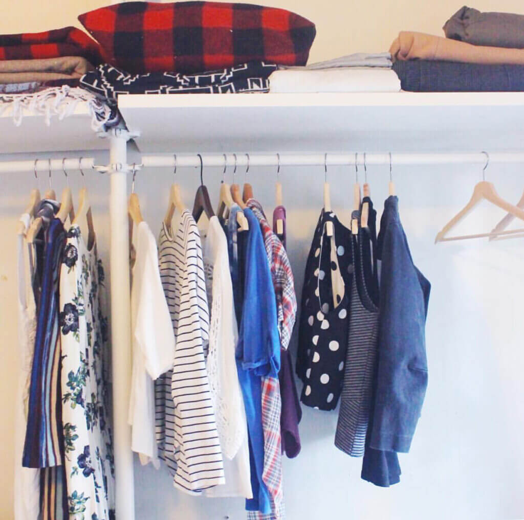 Clothes on hangers and on a shelf