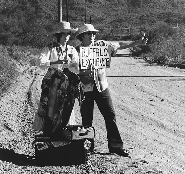 Spencer Block hitchhiking with a Buffalo Exchange sign