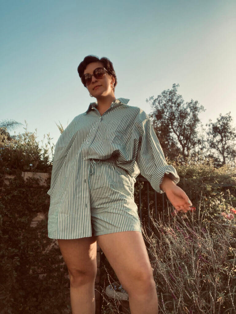 Paris wearing a two piece striped set and sunglasses posing outside