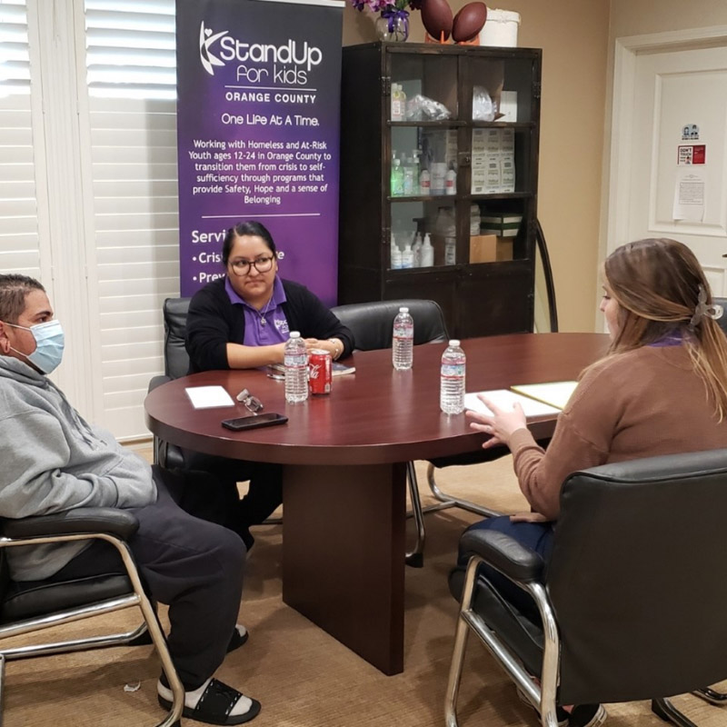 Three people having a meeting at StandUp for Kids