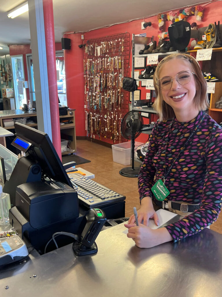 Buffalo Exchange employee writing note at cash register