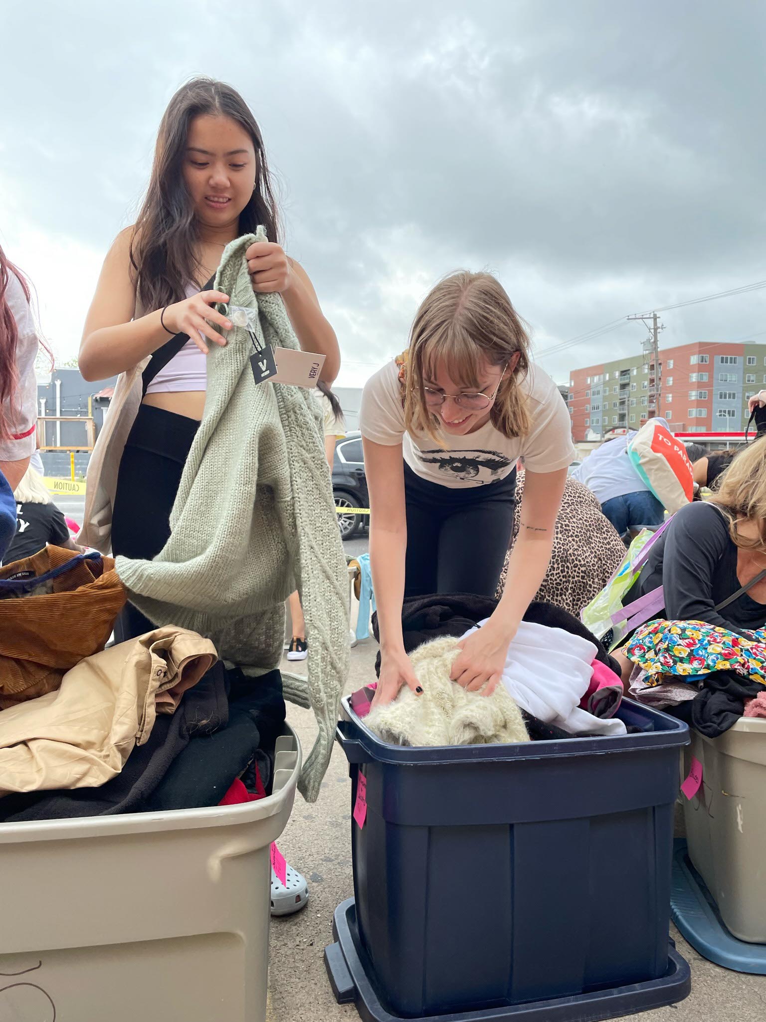 Two women going through bins of clothes outside Buffalo Exchange