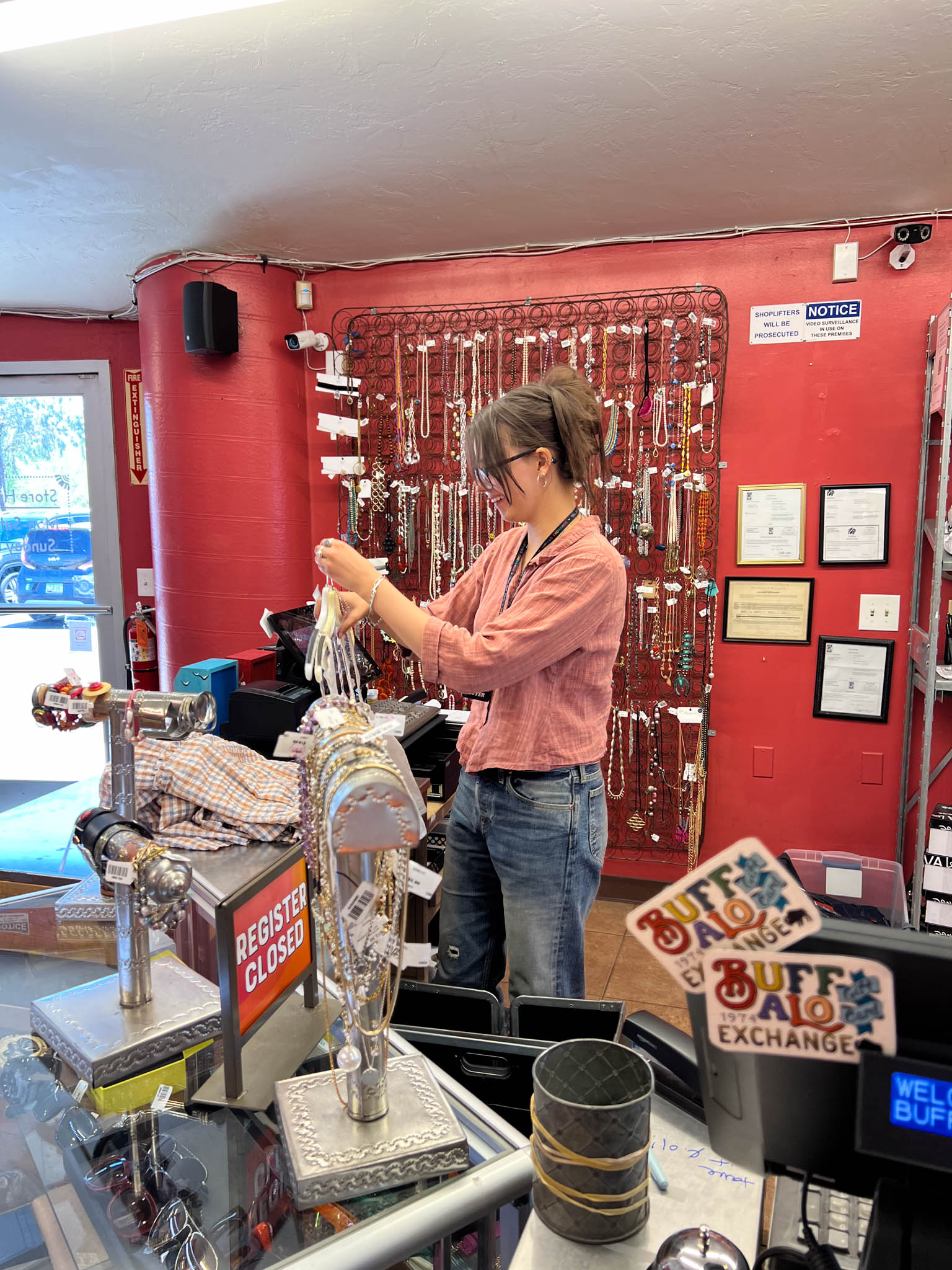 Store employee working behind the counter ringing up the clothing items