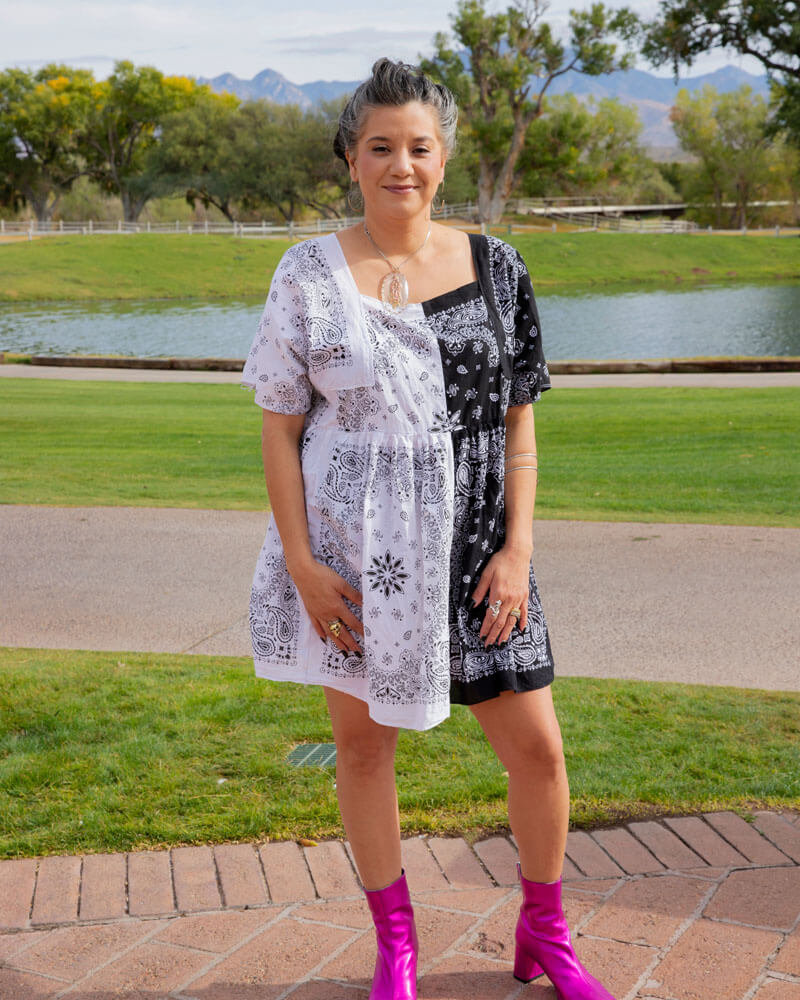 Marisa in a patchwork dress with a black and white handkerchief print and pink metallic boots