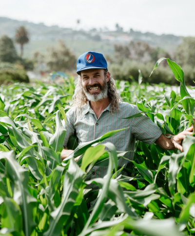 Guy standing in a lush green field