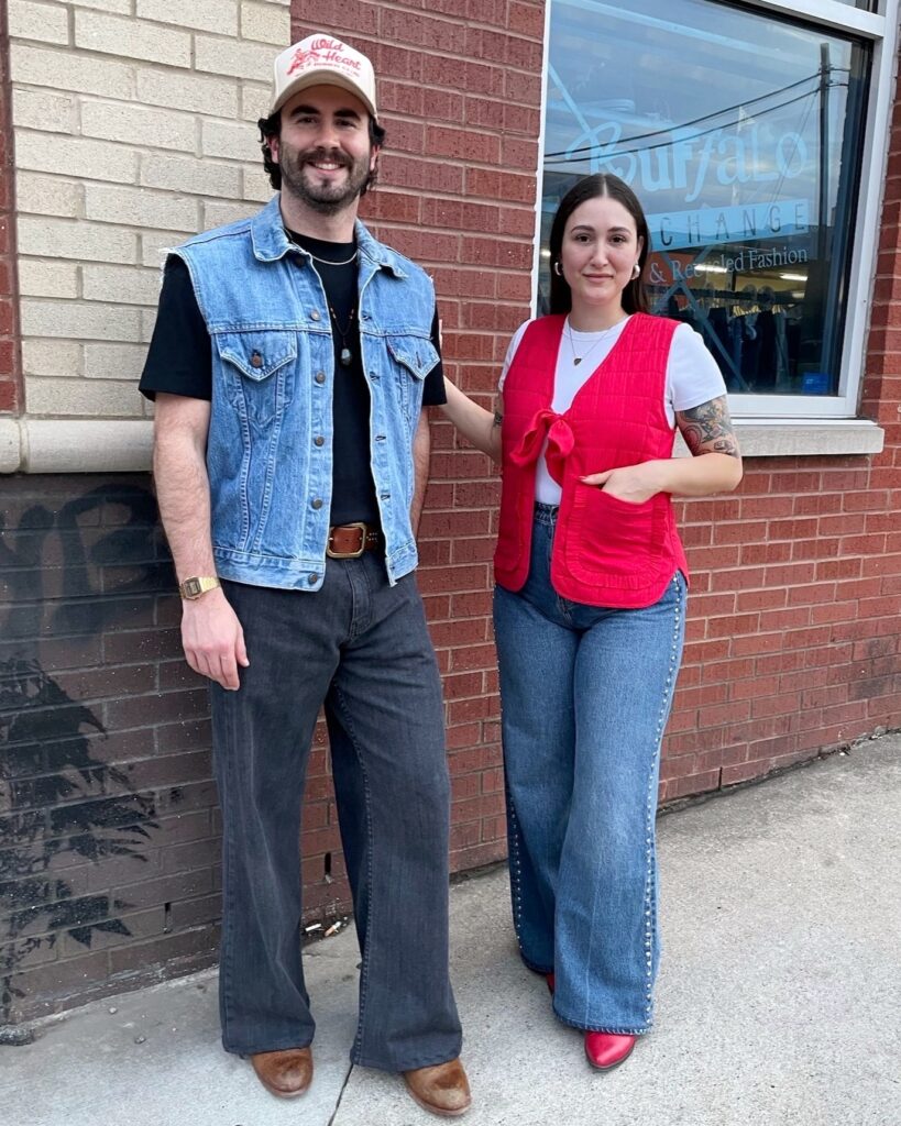 Two people wearing oversized vests and jeans