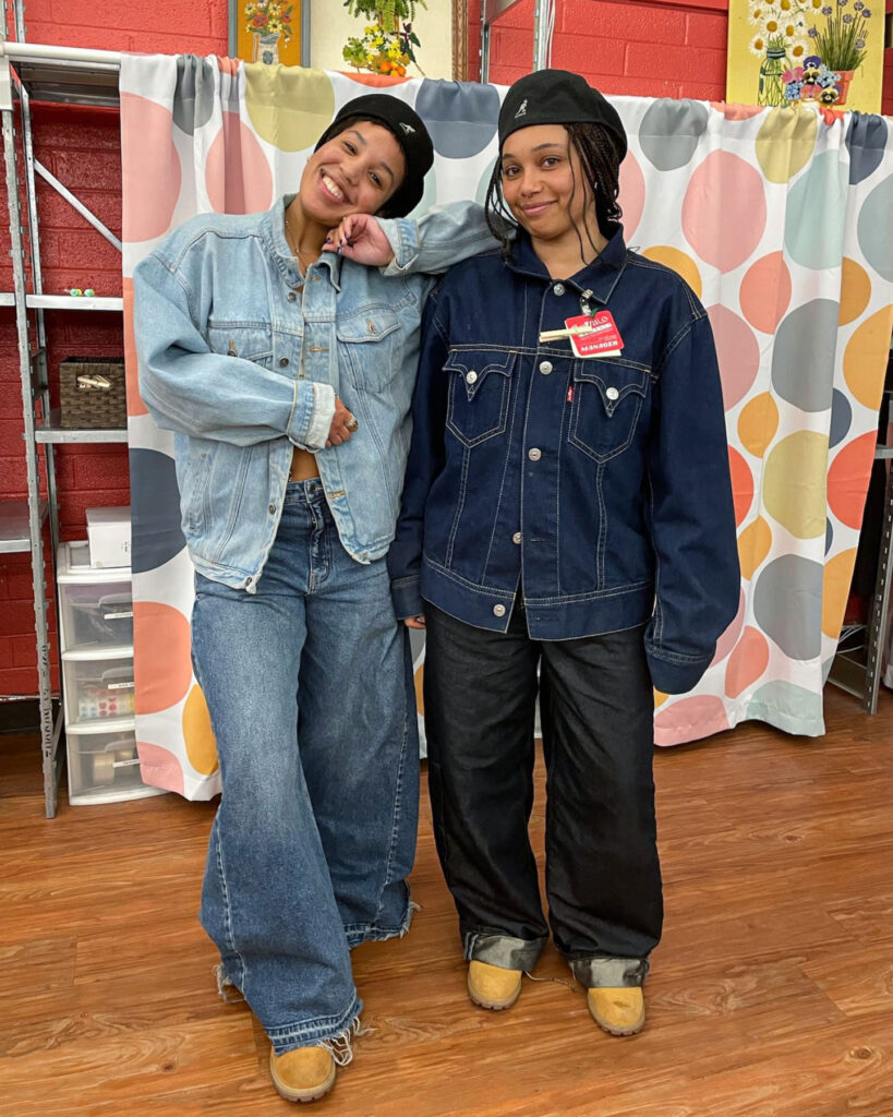 Two people wearing matching double-denim outfits and tan boots