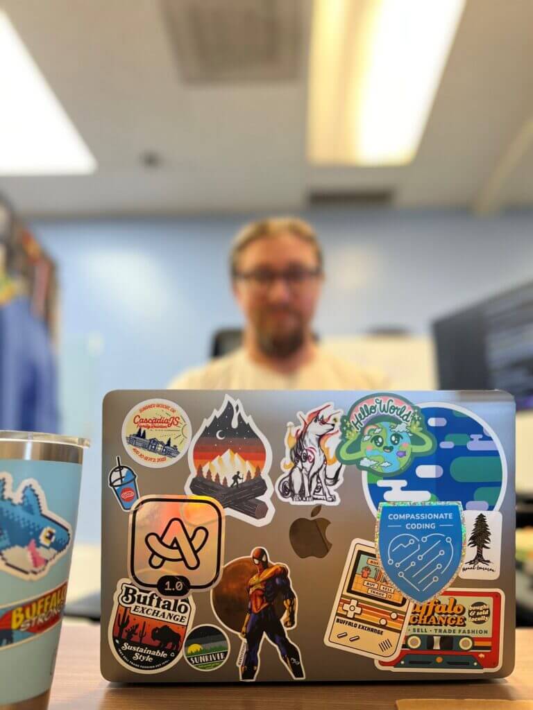 man behind a laptop with stickers