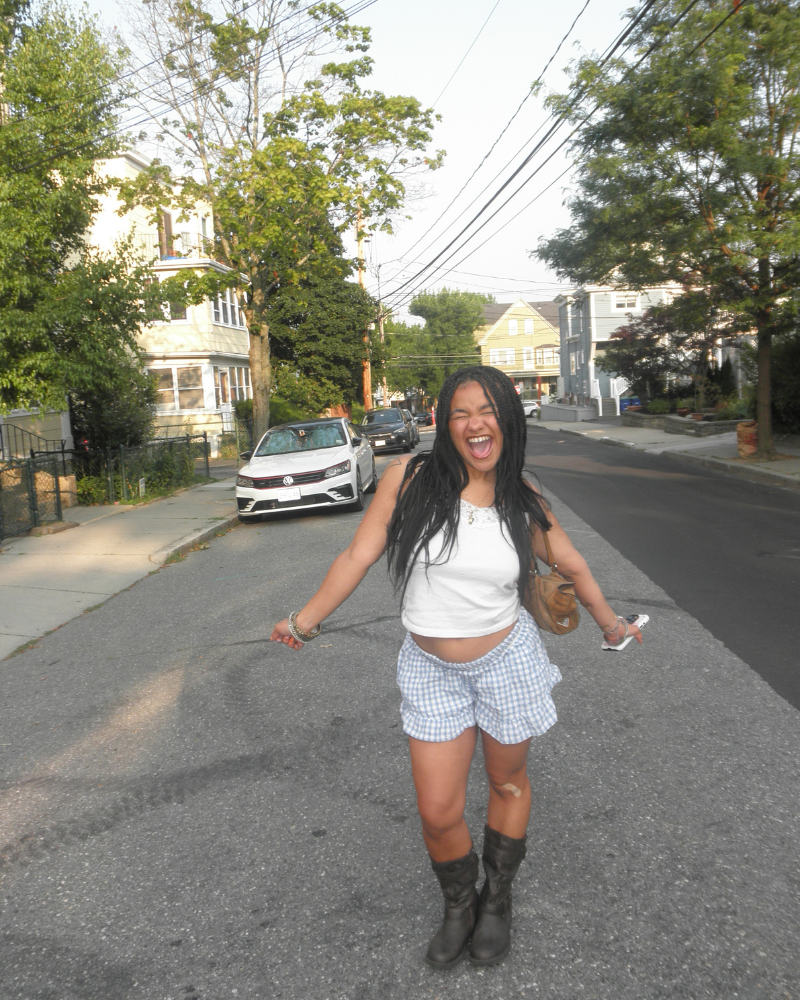Untitled design (1) woman standing in middle of empty street smiles with arms outstretched