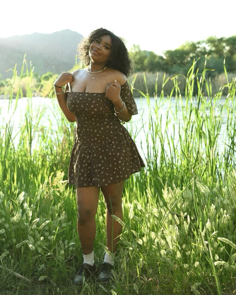 Untitled design woman standing in a meadow near a lake