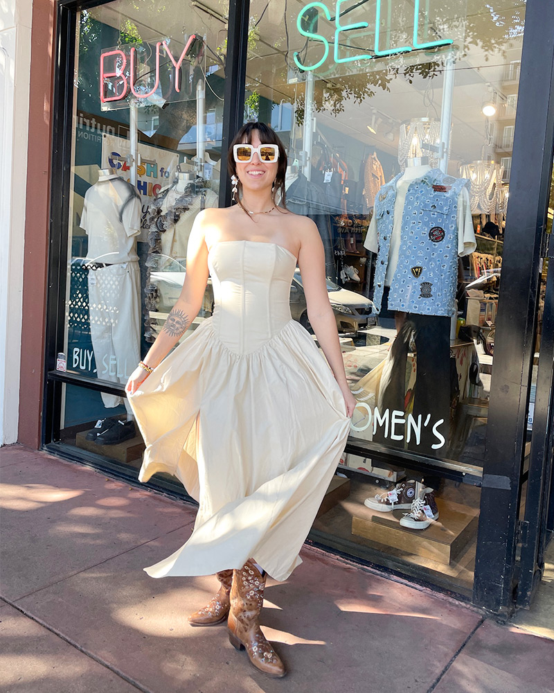 Blog-2-Edited Woman wearing cream strapless dress and brown western boots stands in front of shop window