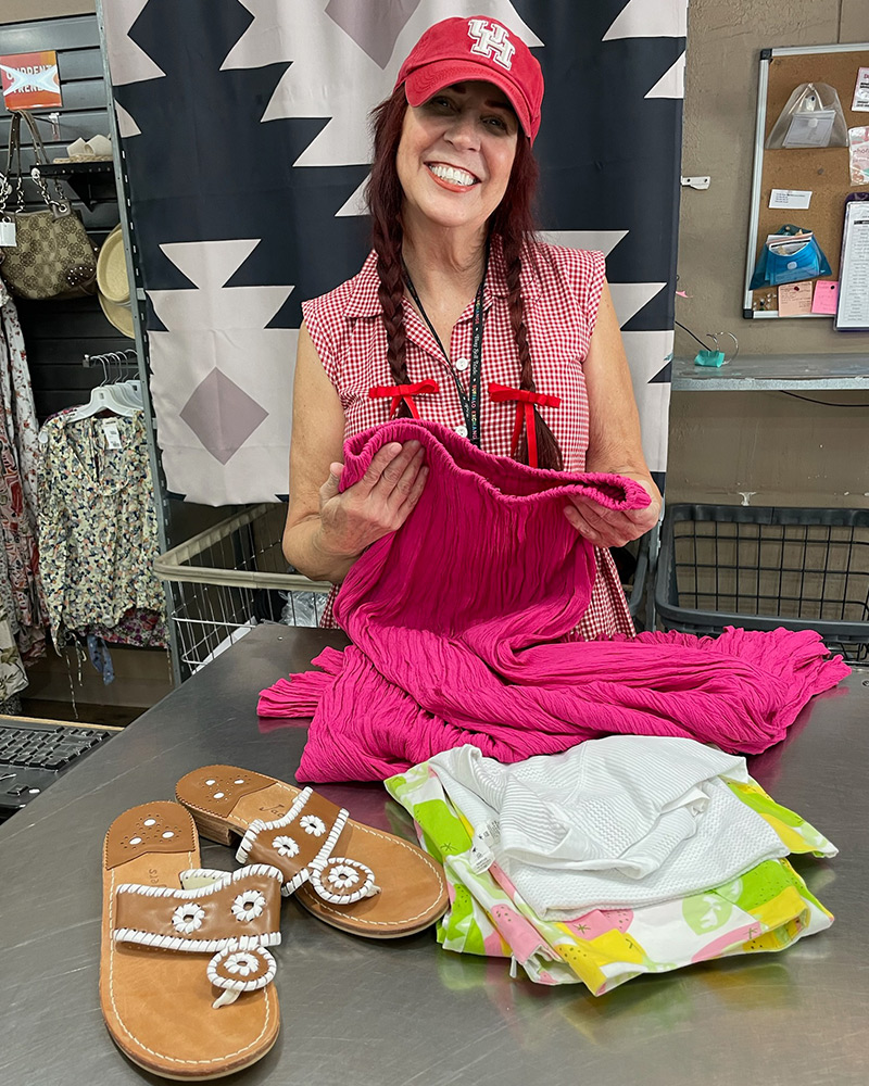 Blog-24-Edited A Buffalo Exchange Buyer smiles for the camera while holding clothing behind a counter