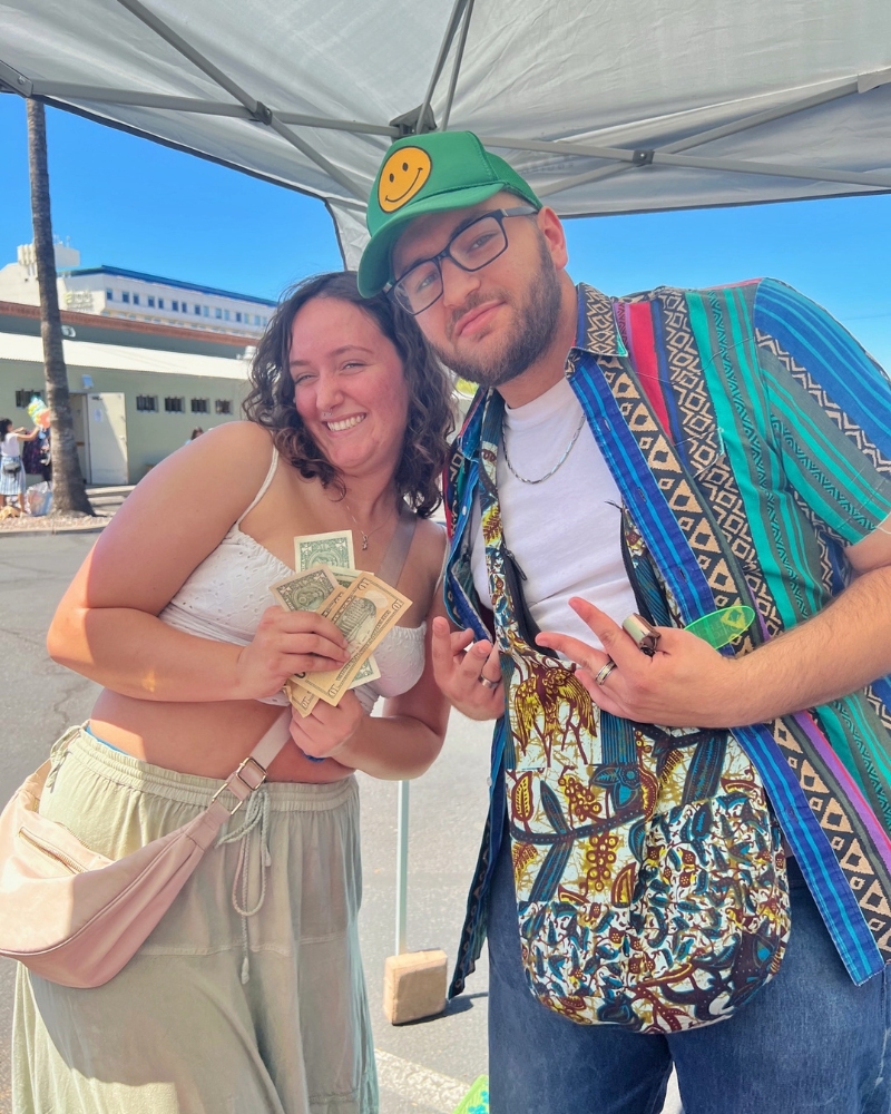 eday blog pic 7 resized a couple pose holding dollar bills while standing under a pop up tent