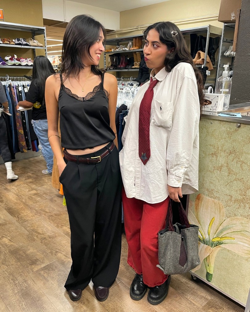 Customers in business casual - one in a black silk cami and low-rise slacks, the other in a white Ralph Lauren button down, red baggy jeans and a matching red tie