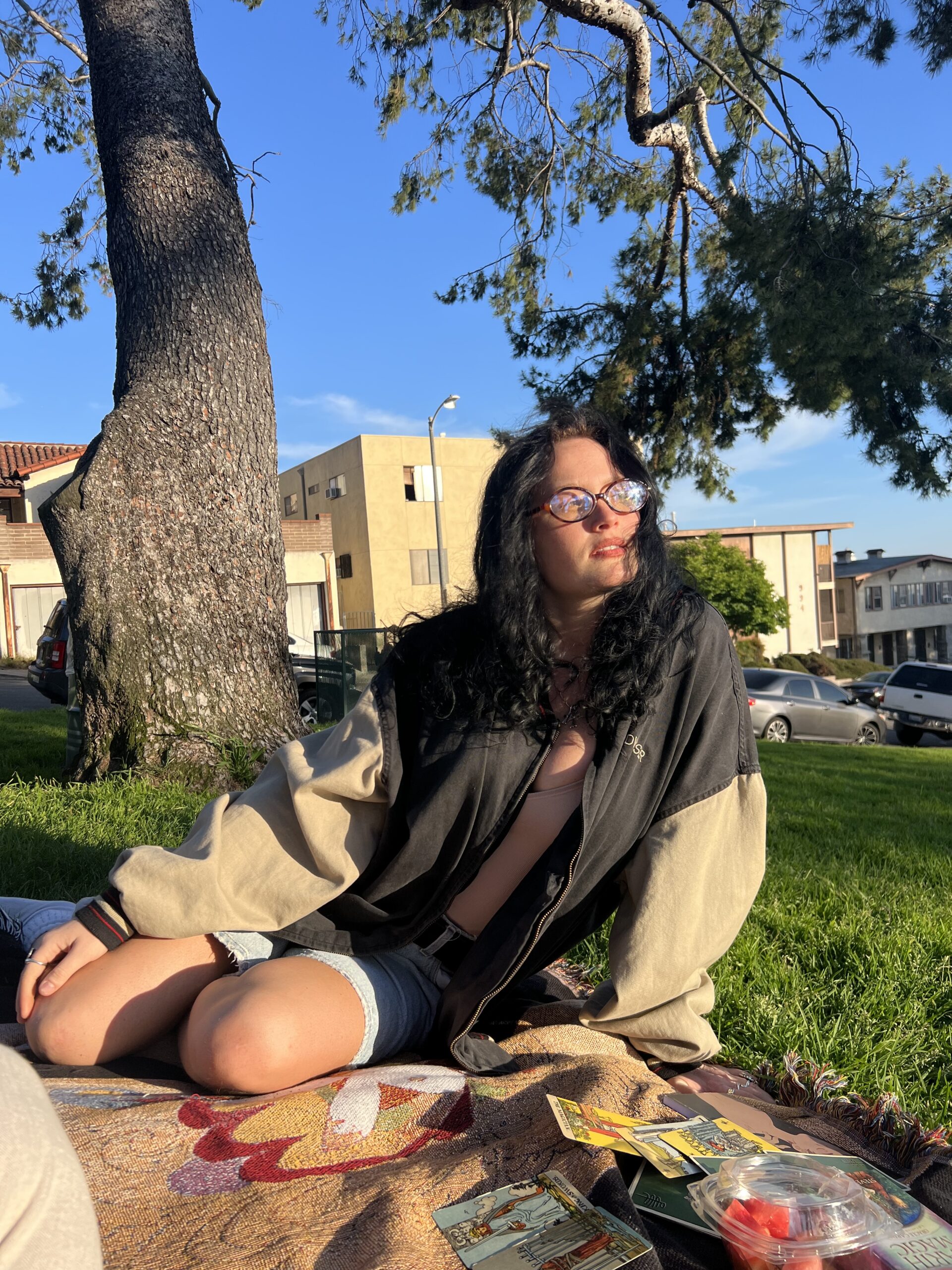 Buffalo Exchange employee Maeve sitting at the park posing