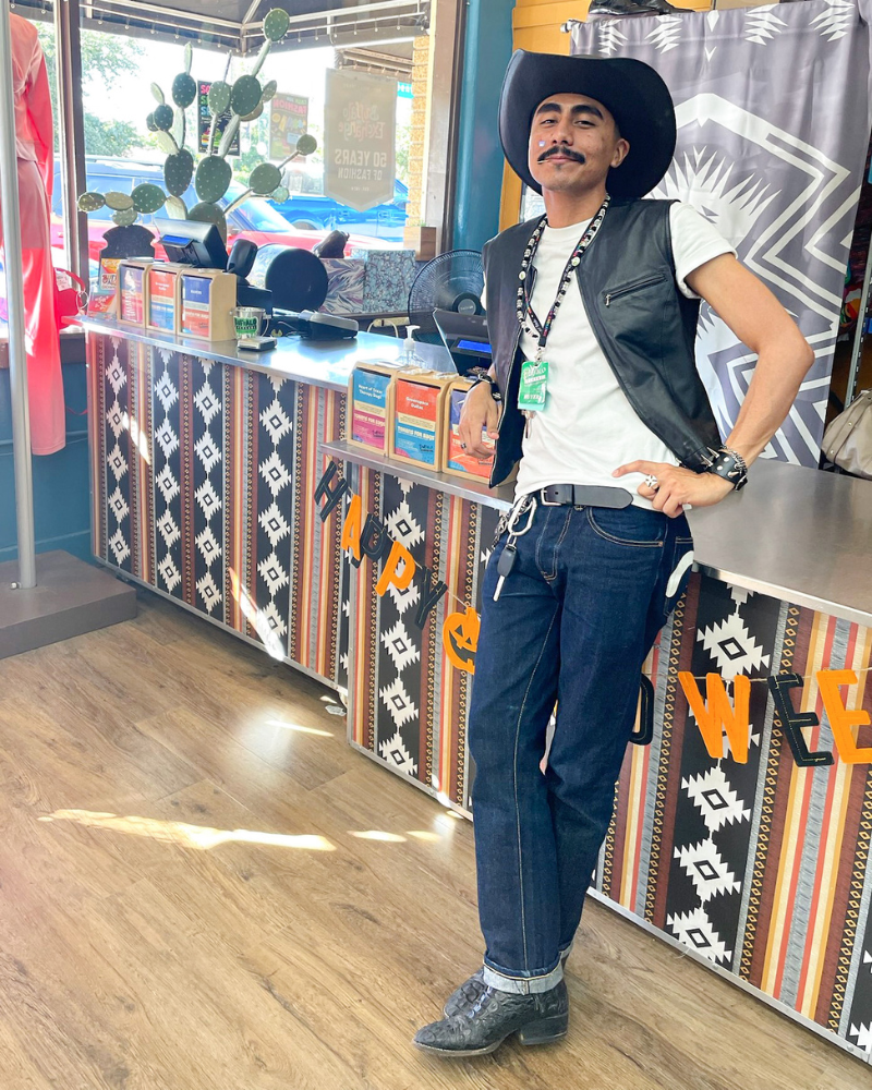 Buffalo Employee in white t-shirt, leather vest, jeans and a cowboy hat with toothpick in their mouth