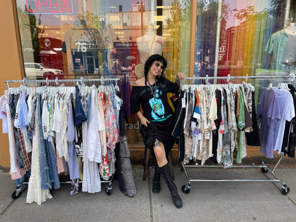 Kat in front of racks of clothes
